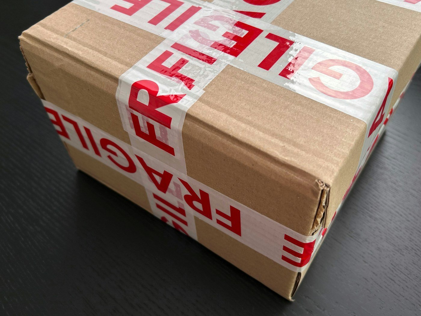 Cardboard carton sealed with printed packaging tape; category reference photograph