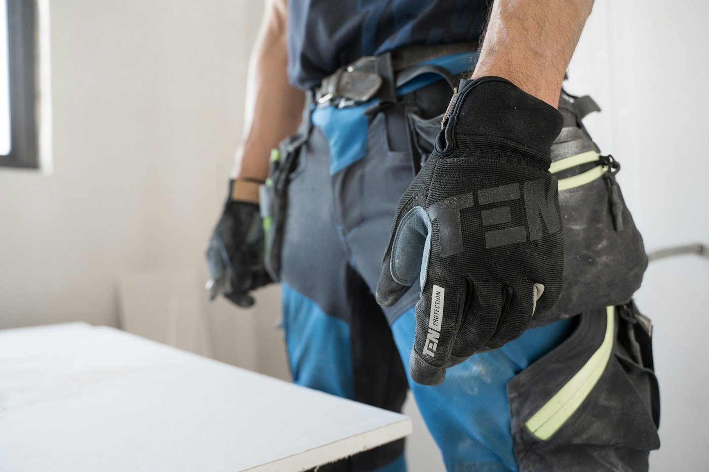 Worker wearing black and blue work gloves; category reference photograph